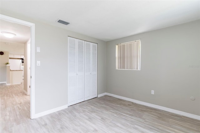 10600 Oleander Dr, Port Richey, FL 34668 - unfurnished bedroom with light wood finished floors and a closet