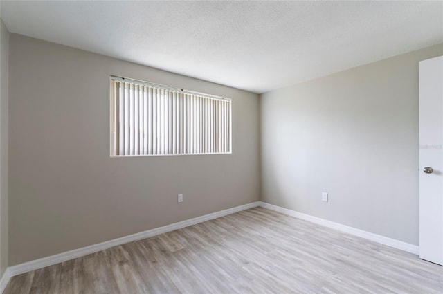 10600 Oleander Dr, Port Richey, FL 34668 - unfurnished room featuring light wood finished floors and a textured ceiling