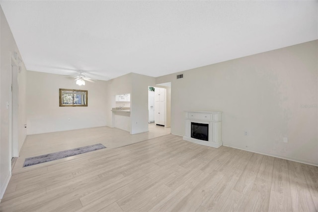3134 Lake Pine Way Unit F2, Tarpon Springs, FL 34688 - unfurnished living room featuring light wood-type flooring, a fireplace, and ceiling fan