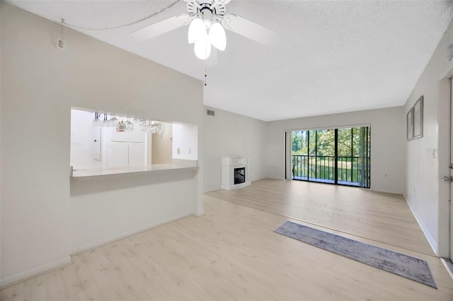 3134 Lake Pine Way Unit F2, Tarpon Springs, FL 34688 - unfurnished living room featuring wood finished floors, a fireplace, and ceiling fan