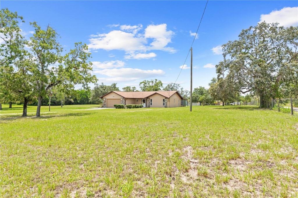 13180 Montour St, Brooksville, FL 34613 - view of green lawn with a garage