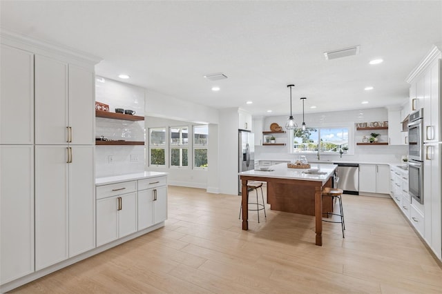 5348 Lawrence Ln, New Port Richey, FL 34652 - kitchen with open shelves, appliances with stainless steel finishes, a breakfast bar area, backsplash, and light countertops