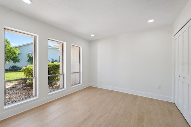 5348 Lawrence Ln, New Port Richey, FL 34652 - unfurnished bedroom with multiple windows, light wood-style floors, recessed lighting, and a closet