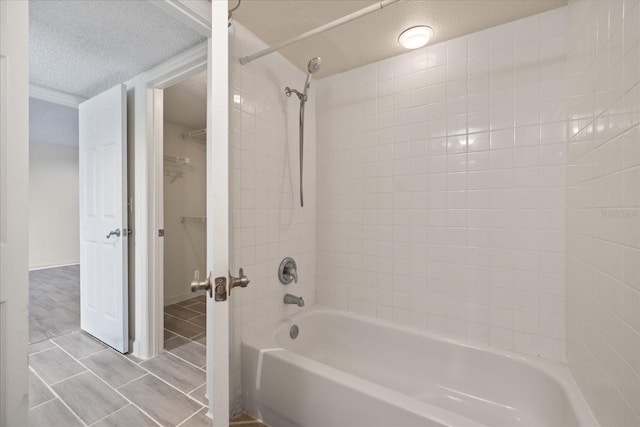 2500 Winding Creek Blvd Unit G106, Clearwater, FL 33761 - full bathroom featuring washtub / shower combination, a textured ceiling, tile patterned flooring, and a spacious closet