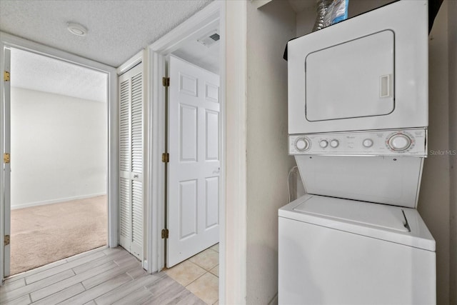 2500 Winding Creek Blvd Unit G106, Clearwater, FL 33761 - washroom with stacked washer / dryer, a textured ceiling, and light wood finished floors