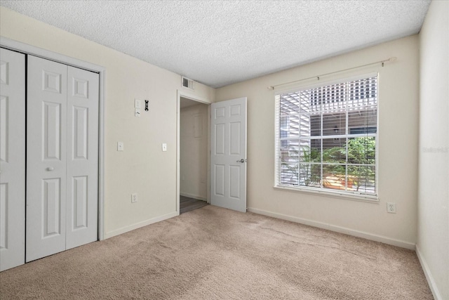 2500 Winding Creek Blvd Unit G106, Clearwater, FL 33761 - unfurnished bedroom featuring carpet floors, a textured ceiling, and a closet
