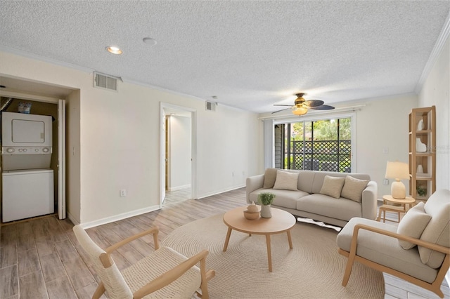 2500 Winding Creek Blvd Unit G106, Clearwater, FL 33761 - living area with estacked washer and dryer, crown molding, light wood finished floors, a textured ceiling, and ceiling fan
