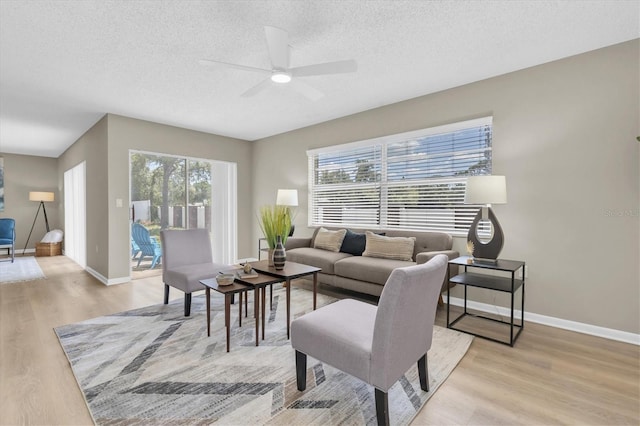 2954 Leisure Ct, Dunedin, FL 34698 - living area featuring light wood-type flooring, ceiling fan, and a textured ceiling