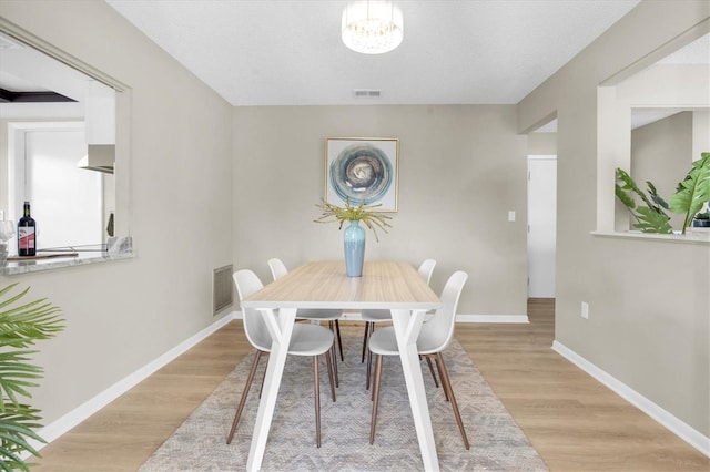 2954 Leisure Ct, Dunedin, FL 34698 - dining area featuring wood finished floors and a chandelier