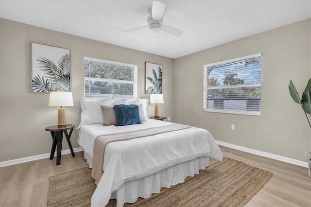 2954 Leisure Ct, Dunedin, FL 34698 - bedroom with multiple windows, light wood-style floors, a textured ceiling, and ceiling fan