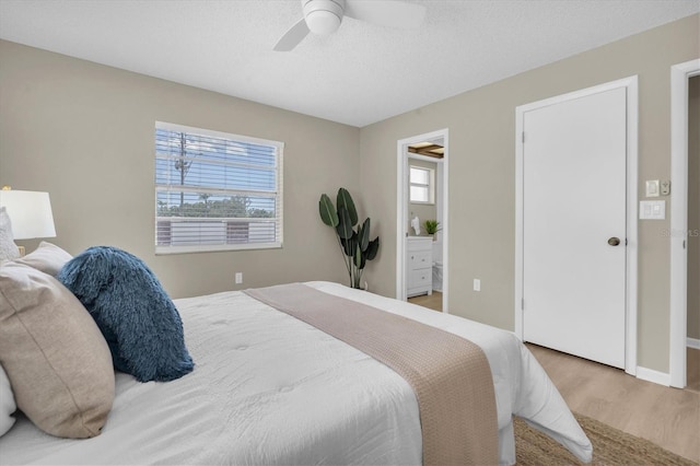 2954 Leisure Ct, Dunedin, FL 34698 - bedroom with multiple windows, wood finished floors, a ceiling fan, ensuite bathroom, and a textured ceiling