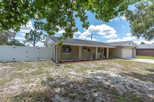 2954 Leisure Ct, Dunedin, FL 34698 - single story home featuring a gate, a garage, concrete driveway, and brick siding