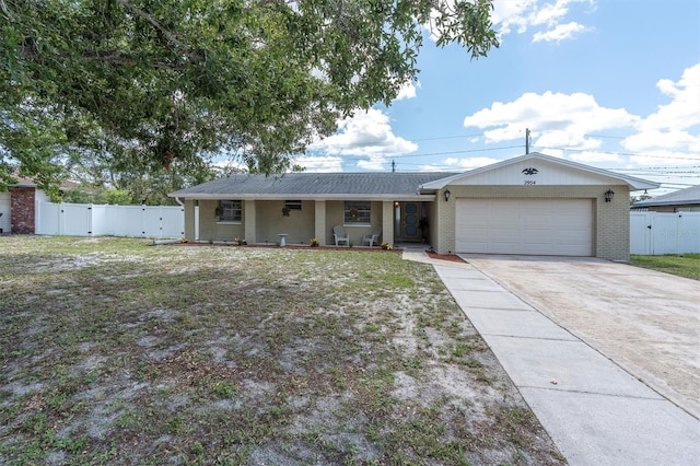 2954 Leisure Ct, Dunedin, FL 34698 - single story home featuring a gate, a garage, driveway, and brick siding