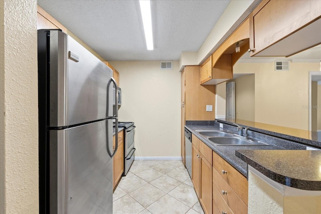 2500 Winding Creek Blvd Unit I106, Clearwater, FL 33761 - kitchen featuring stainless steel appliances, dark countertops, light tile patterned flooring, a peninsula, and a textured ceiling