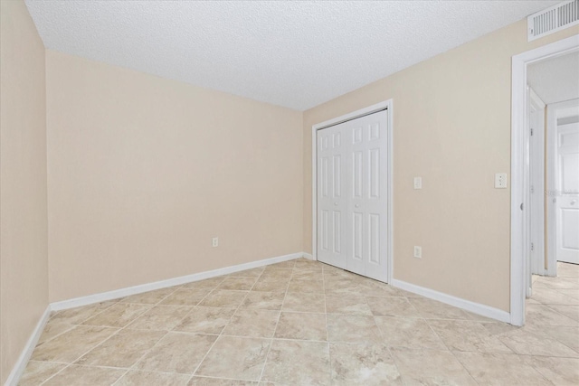 2500 Winding Creek Blvd Unit I106, Clearwater, FL 33761 - unfurnished bedroom with a closet, light tile patterned flooring, and a textured ceiling