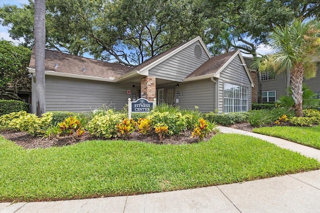 2500 Winding Creek Blvd Unit I106, Clearwater, FL 33761 - view of front of house featuring a front lawn, a shingled roof, and stone siding