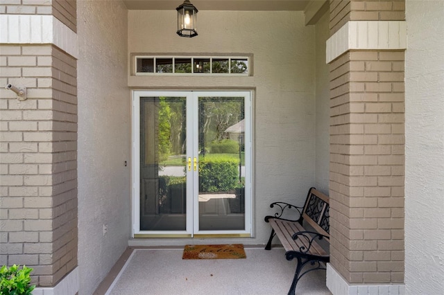 7445 Nature Walk Dr, Spring Hill, FL 34606 - doorway to property with french doors, stucco siding, and brick siding