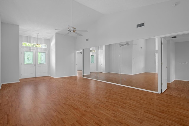 7445 Nature Walk Dr, Spring Hill, FL 34606 - unfurnished living room featuring ceiling fan, light wood-type flooring, high vaulted ceiling, and a chandelier