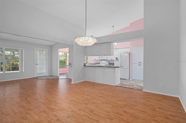 7445 Nature Walk Dr, Spring Hill, FL 34606 - unfurnished living room featuring light wood-type flooring, a chandelier, and high vaulted ceiling