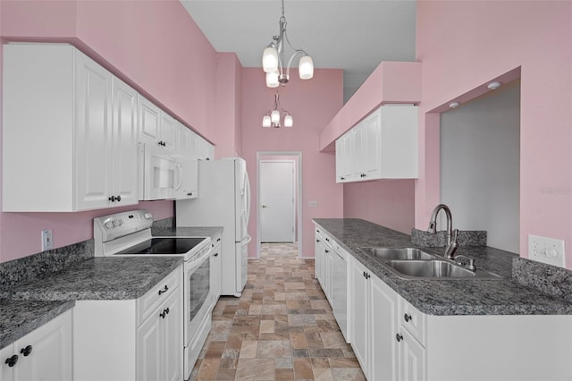 7445 Nature Walk Dr, Spring Hill, FL 34606 - kitchen with white appliances, stone finish floors, white cabinetry, a chandelier, and a high ceiling