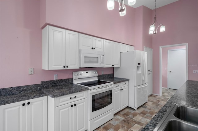 7445 Nature Walk Dr, Spring Hill, FL 34606 - kitchen with white appliances, dark countertops, a towering ceiling, white cabinetry, and hanging light fixtures