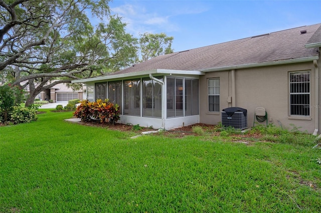 7445 Nature Walk Dr, Spring Hill, FL 34606 - rear view of property with a sunroom, a lawn, stucco siding, and a shingled roof