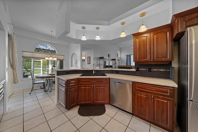 14178 Pullman Dr, Spring Hill, FL 34609 - kitchen with appliances with stainless steel finishes, a tray ceiling, light tile patterned floors, light countertops, and a textured ceiling