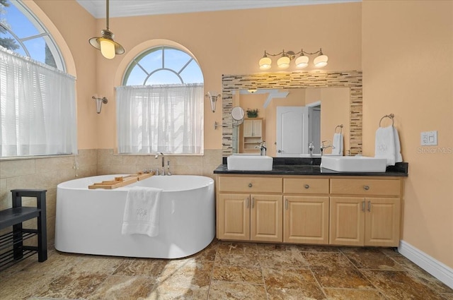 14178 Pullman Dr, Spring Hill, FL 34609 - full bathroom with a freestanding tub, tile walls, double vanity, and stone finish flooring