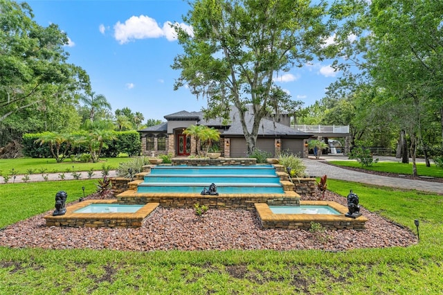 26221 Pheasant Run, Wesley Chapel, FL 33544 - surrounding community with a jacuzzi, a lawn, a pool, driveway, and a garage