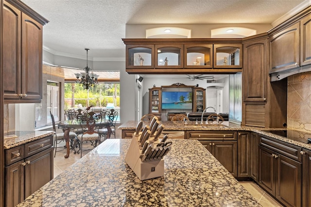 26221 Pheasant Run, Wesley Chapel, FL 33544 - kitchen featuring black electric cooktop, a chandelier, light tile patterned floors, tasteful backsplash, and a textured ceiling