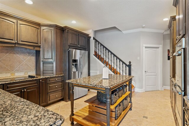 26221 Pheasant Run, Wesley Chapel, FL 33544 - kitchen featuring stainless steel fridge, ornamental molding, decorative backsplash, stone countertops, and light tile patterned floors