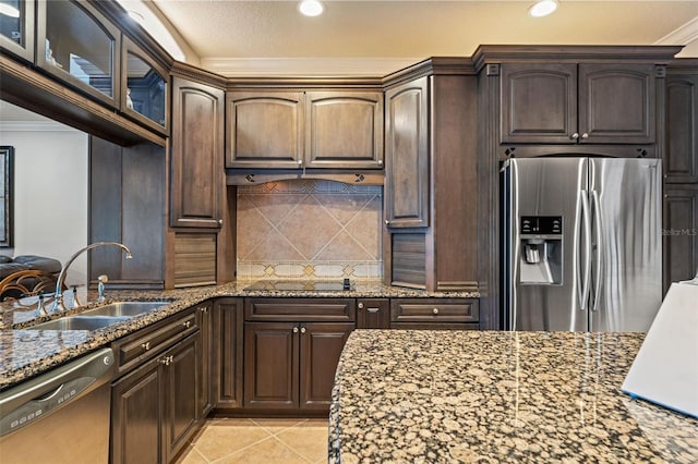 26221 Pheasant Run, Wesley Chapel, FL 33544 - kitchen with appliances with stainless steel finishes, stone countertops, decorative backsplash, dark brown cabinetry, and ornamental molding