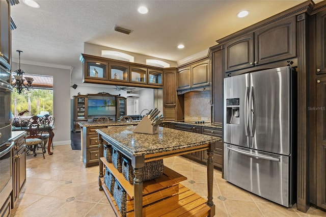 26221 Pheasant Run, Wesley Chapel, FL 33544 - kitchen featuring stainless steel fridge with ice dispenser, light tile patterned floors, dark stone countertops, tasteful backsplash, and recessed lighting