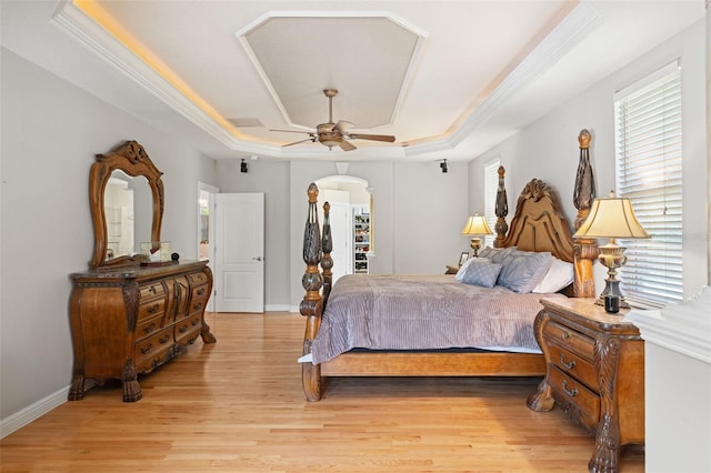 26221 Pheasant Run, Wesley Chapel, FL 33544 - bedroom with a raised ceiling, light wood finished floors, crown molding, ceiling fan, and arched walkways