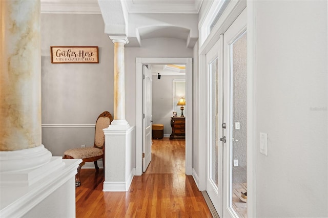 26221 Pheasant Run, Wesley Chapel, FL 33544 - hallway featuring ornate columns, crown molding, light wood-style floors, and plenty of natural light