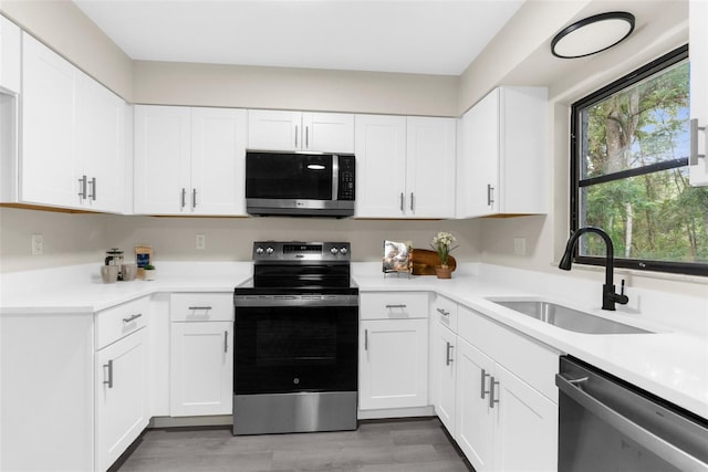 5215 Azalea Cir, Dade City, FL 33523 - kitchen with stainless steel appliances, light countertops, white cabinets, and light wood-style floors