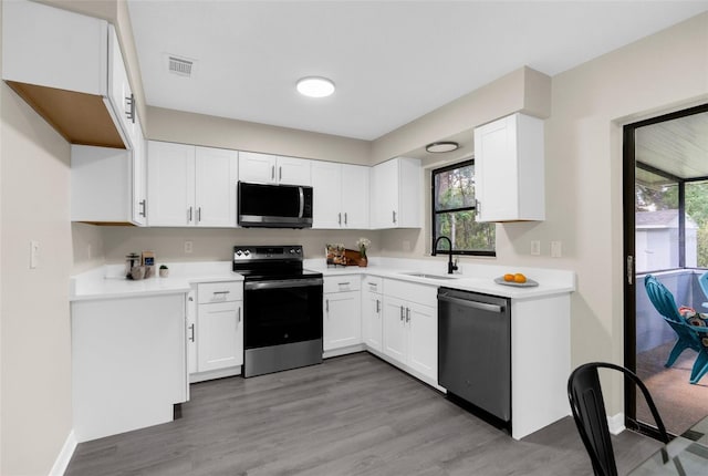 5215 Azalea Cir, Dade City, FL 33523 - kitchen with stainless steel appliances, white cabinetry, light wood-style floors, and light countertops