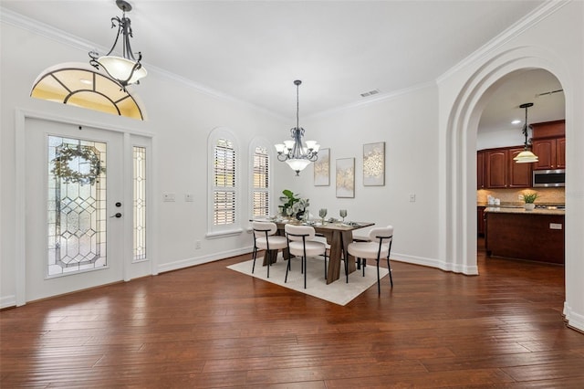 9829 Sorbonne Loop, Seffner, FL 33584 - dining space featuring a chandelier, plenty of natural light, ornamental molding, dark wood-type flooring, and arched walkways
