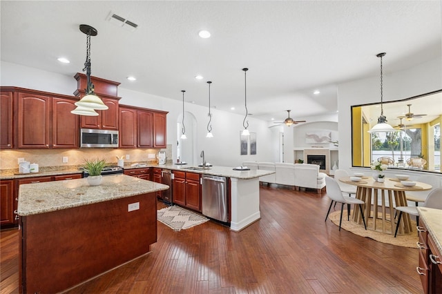 9829 Sorbonne Loop, Seffner, FL 33584 - kitchen with appliances with stainless steel finishes, ceiling fan, a peninsula, open floor plan, and backsplash