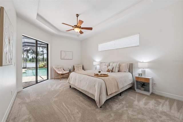 9829 Sorbonne Loop, Seffner, FL 33584 - bedroom with carpet floors, access to exterior, multiple windows, and a tray ceiling