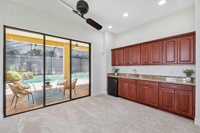 9829 Sorbonne Loop, Seffner, FL 33584 - kitchen featuring light colored carpet, dishwasher, light stone counters, recessed lighting, and dark brown cabinets