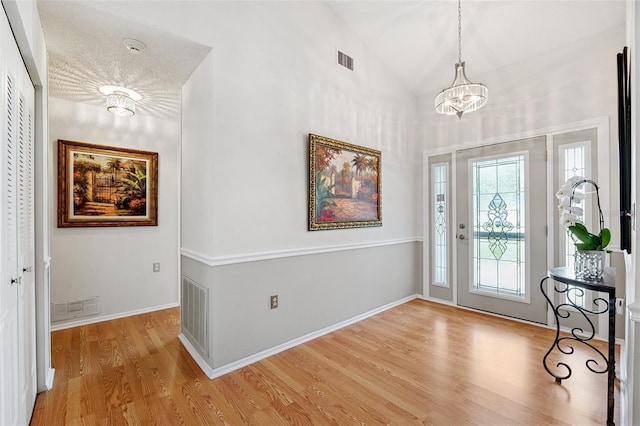 3204 Payne St, New Port Richey, FL 34655 - foyer entrance with a chandelier, light wood-style flooring, and vaulted ceiling