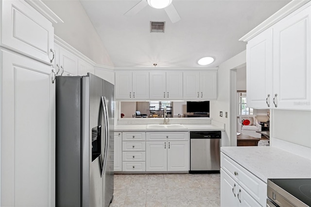 3204 Payne St, New Port Richey, FL 34655 - kitchen with appliances with stainless steel finishes, light countertops, white cabinetry, and lofted ceiling