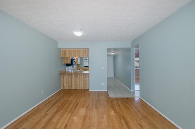 5640 Ferguson Ct Unit 2203, New Port Richey, FL 34652 - kitchen with light wood-style floors, a textured ceiling, and light countertops