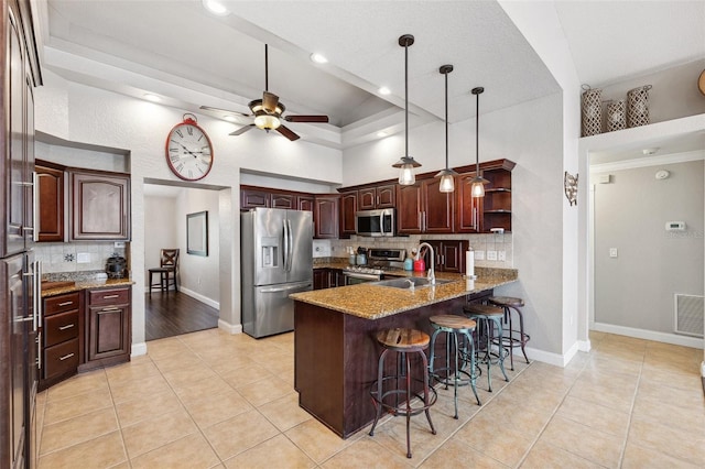 1478 Brigadier Dr, Spring Hill, FL 34608 - kitchen with stainless steel appliances, a peninsula, a kitchen breakfast bar, backsplash, and light tile patterned floors