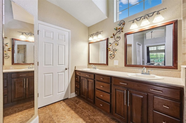 1478 Brigadier Dr, Spring Hill, FL 34608 - bathroom featuring double vanity, plenty of natural light, vaulted ceiling, and a textured wall