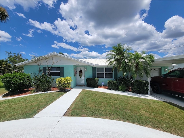 6737 Clark St, Hudson, FL 34667 - ranch-style house with a front lawn, stucco siding, an attached garage, and a metal roof