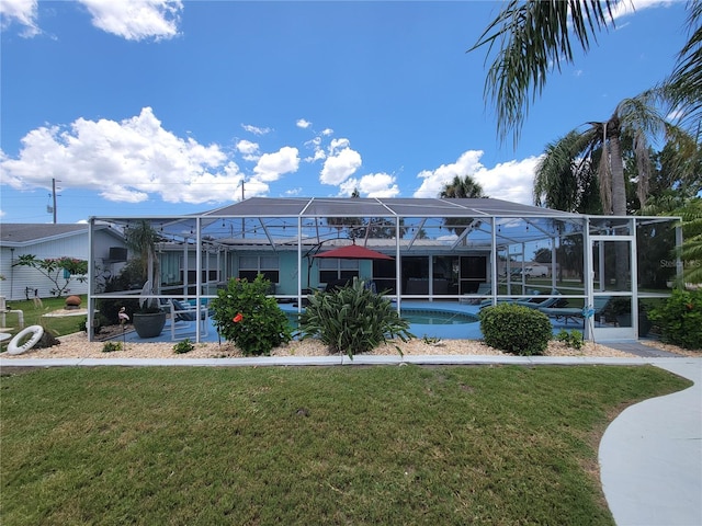6737 Clark St, Hudson, FL 34667 - rear view of house with an outdoor pool, a yard, glass enclosure, and a patio
