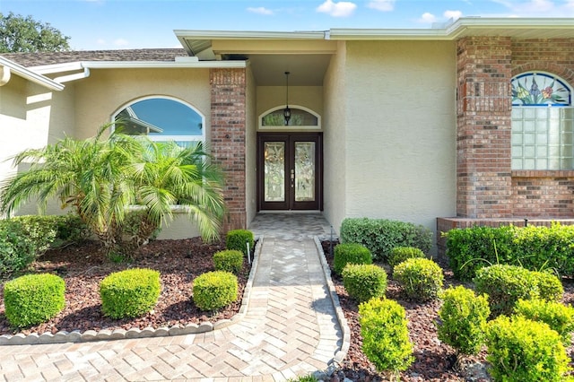 7328 Blue Skies Dr, Spring Hill, FL 34606 - entrance to property with french doors, stucco siding, and brick siding