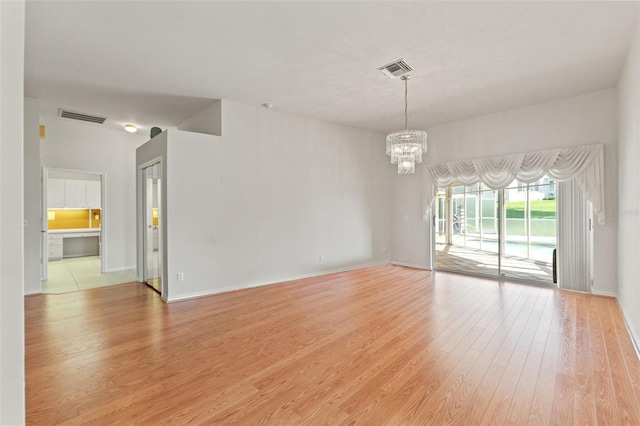 7328 Blue Skies Dr, Spring Hill, FL 34606 - spare room featuring a chandelier and light wood finished floors